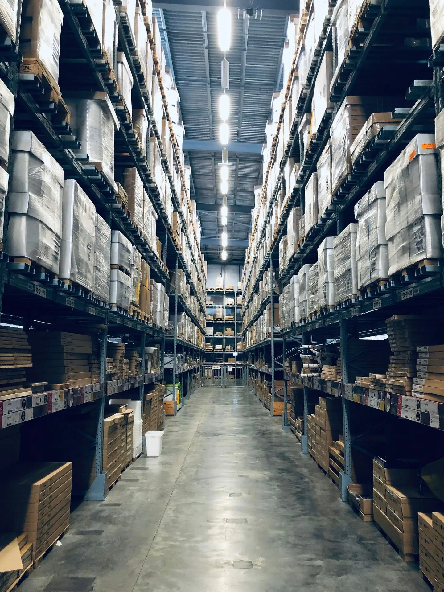Rows of stocked warehouse shelving in a manufacturing facility